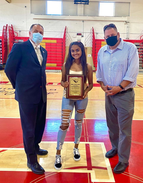 Mr. Ross, Krystal, and Mr. Sandaal posing for a picture with the scholar athlete plaque after the virtual winter varsity awards night.