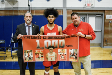 Niko Barnes poses with Mr. Charles Ross and Mr. David Sandaal, with a poster commemorating a milestone in his career.