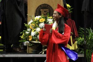 Geraldine Mendoza ‘22 receiving her high school diploma and showing it towards the audience.