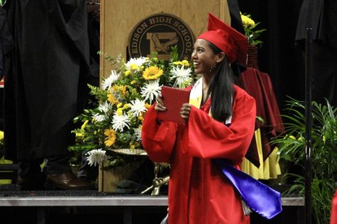 Geraldine Mendoza ‘22 receiving her high school diploma and showing it towards the audience.