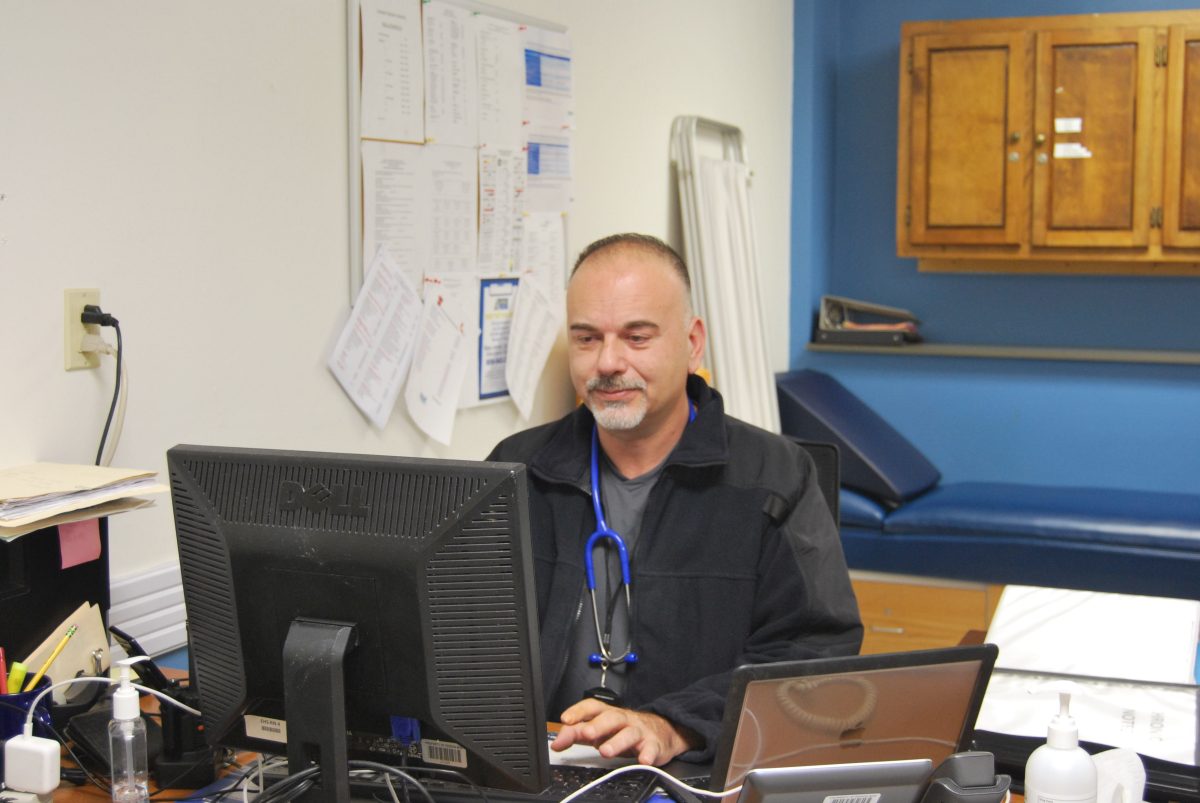 Nurse Mirano works on his computer in the front of the nurses office.