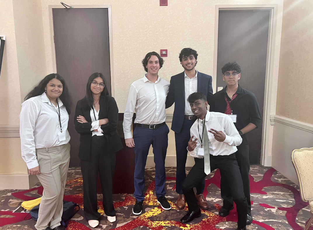 (From left) Ambar Phatak 27, Ainie Syed 26 and (from right) Madhav Mandala 24 and Ishaan Shetty 24 pose with their chairs from the Economic and Financial (ECOFIN) Committee.