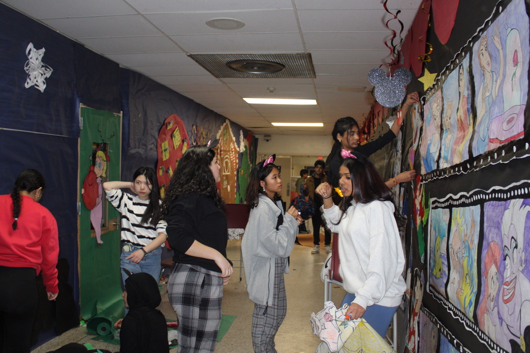 The Freshman class (at left) work on their Grinch-themed wall left. Juniors (right) put up the final decorations to complete their wall.