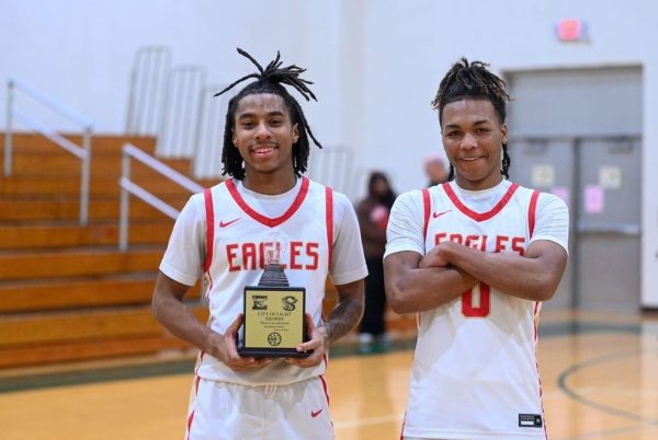 Ricky Harvey 26 holds a trophy after victory against JP Stevens alongside teammate Toriahn Rattray 26. Bringing the trophy back to EHS was a milestone for this years team.