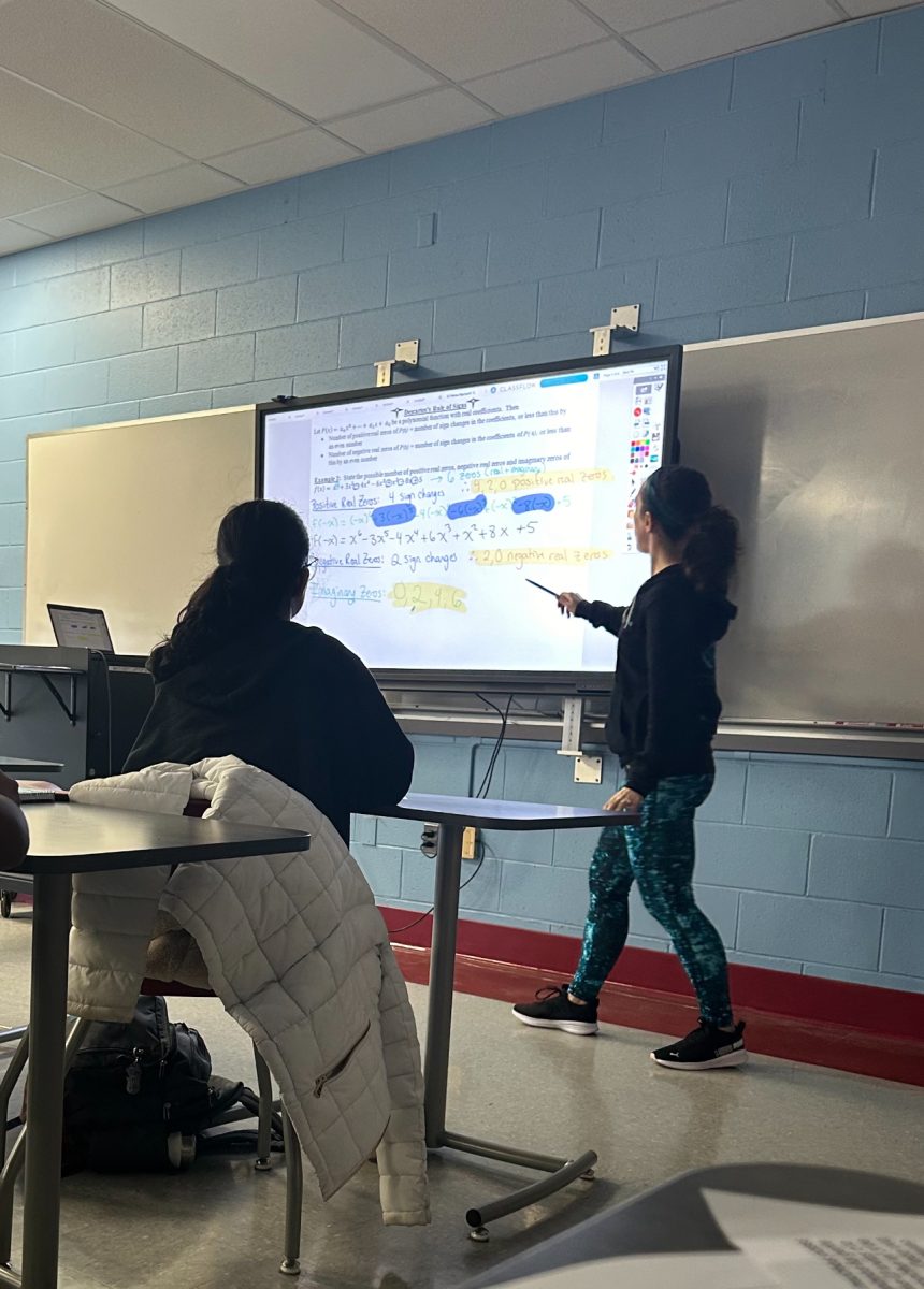 Ms. Andriano teaches rules of signs to her freshmen STEM Algebra 2H class in period 12. She focuses on teaching her students step by step, as their understanding of the lesson is of utmost importance to her.