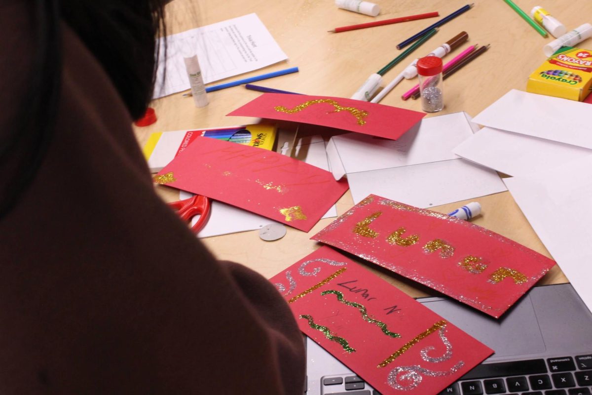 Students decorate red envelopes (紅包; hóngbāo). These red envelopes are traditionally filled with money and given to children on Lunar New Year to signify luck and fortune.