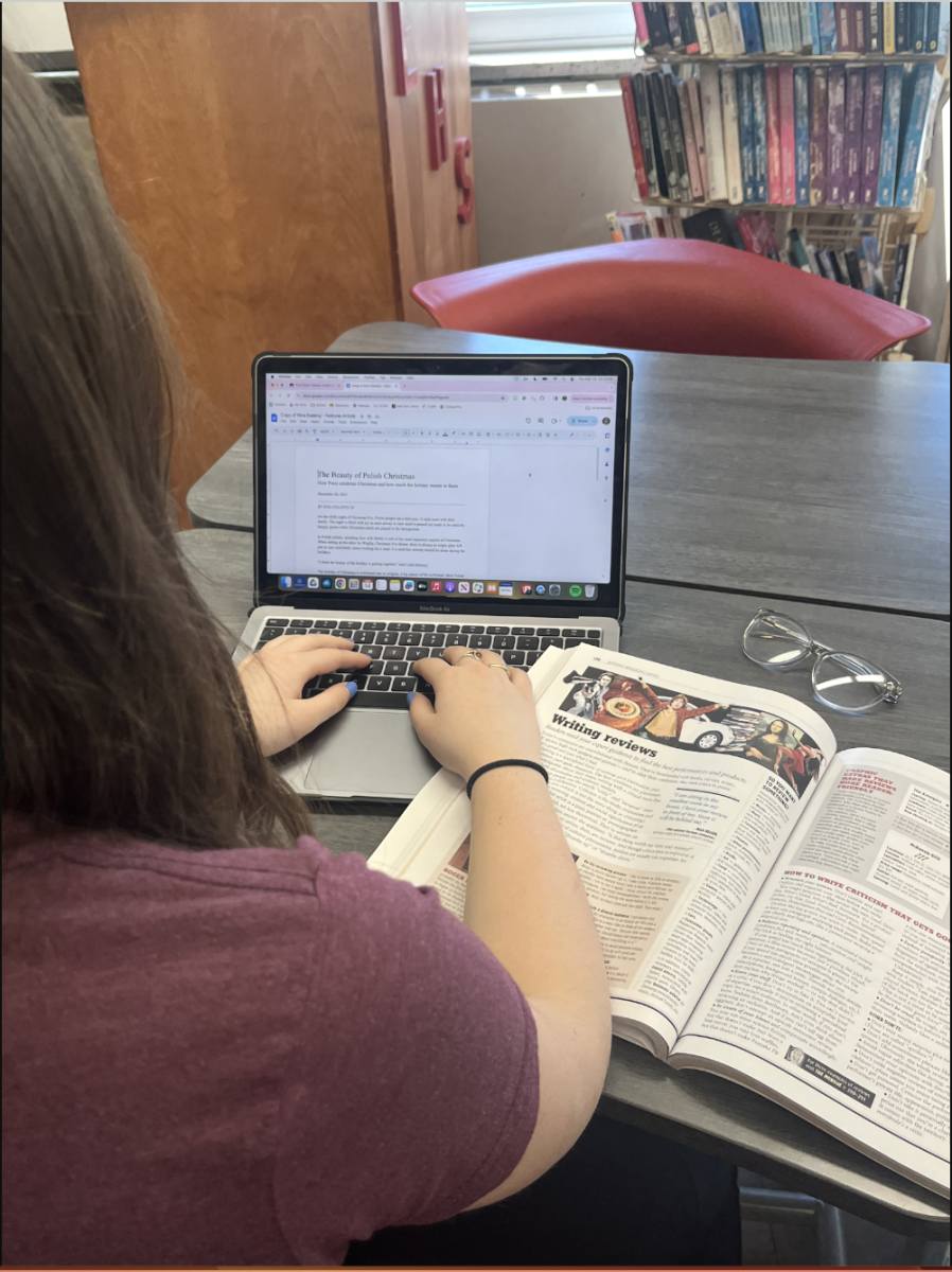 Journalism and Media student Nina Stalenyj 26 works on an article while referencing the course textbook.
