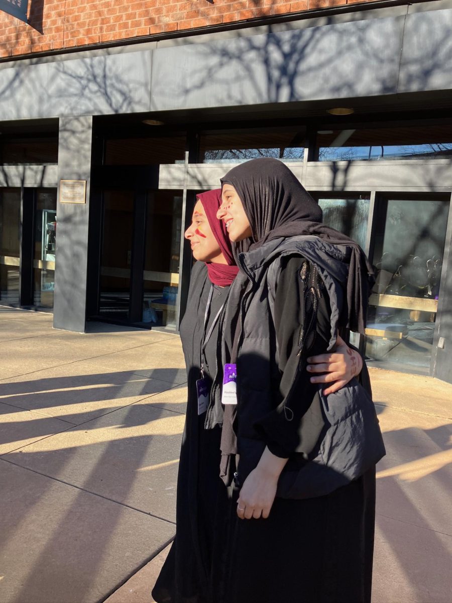 Wearing red and yellow face paint to show their EHS pride, Saja Omar '25 and Haddeel Omar '27 pose for a picture outside of the awards ceremony.