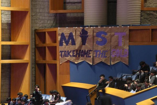A banner in the auditorium saying Take Home The Gold reflects the ambition of the MIST competitors.
