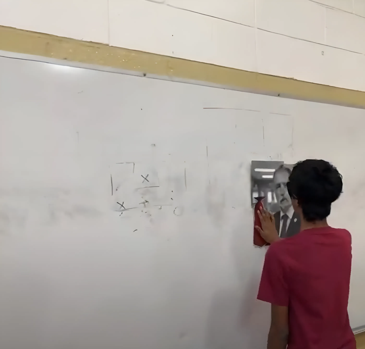 Navaneeth Krishna 27 participates in the Pin the Tie on Mr. Ross game, struggling to place the tie close to the target.