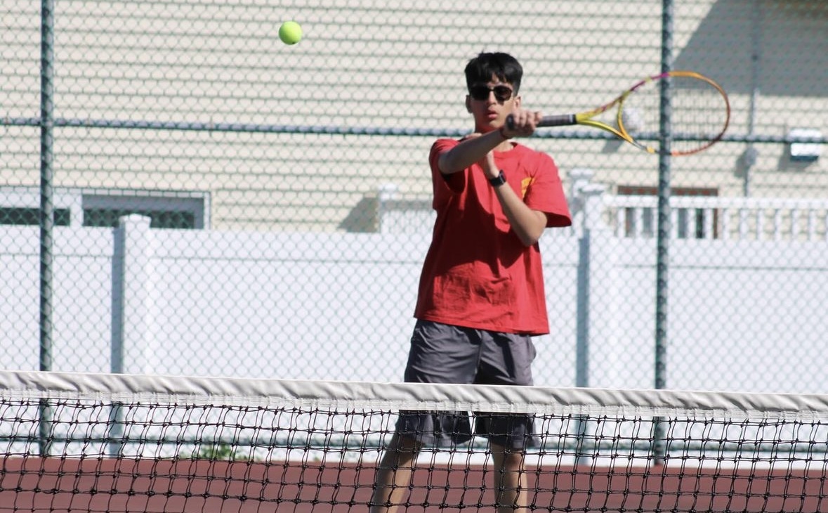 Ashmit Gandhi 26 follows through on a forehand as he readies himself to return the ball.