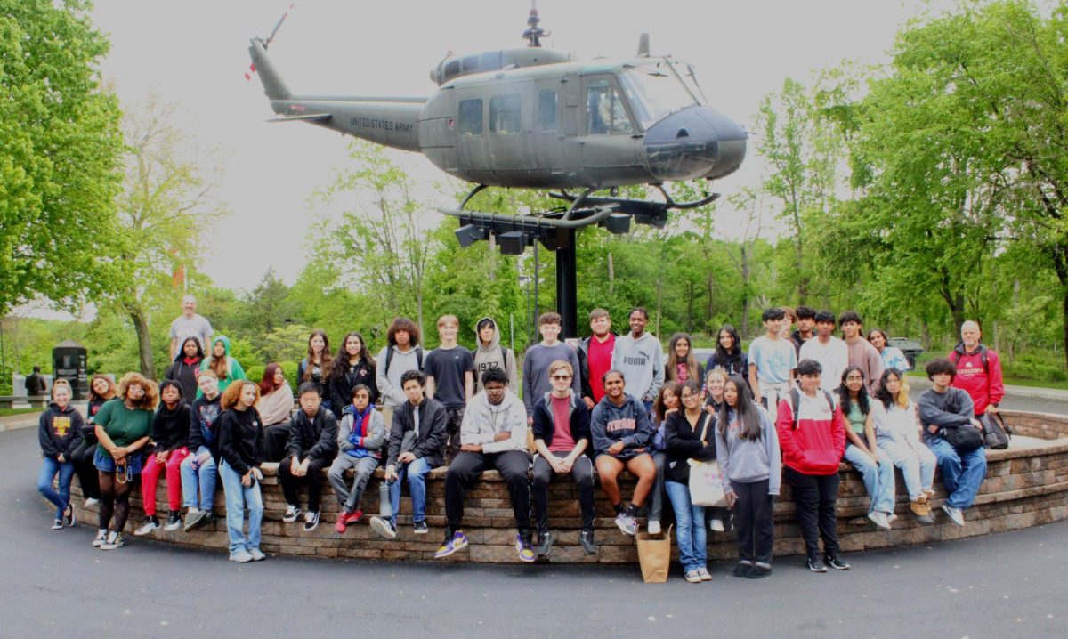 Students and teachers pose in front of a Bell UH-1 Iroquois Huey helicopter, which served in combat during the Vietnam War. The trip was coordinated by Ms. Leanne Rubiano.