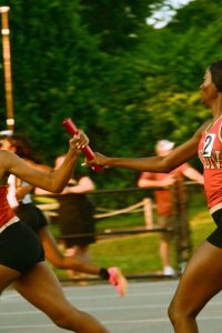 Noreen Amponsah '24 passes the baton to Grace White '25 during the Girls' 4x400 meter relay.  The girls team (Noreen Amponsah '24, Grace White '25, Hailey Dawson '24, Jada Bonds '24) places second overall.