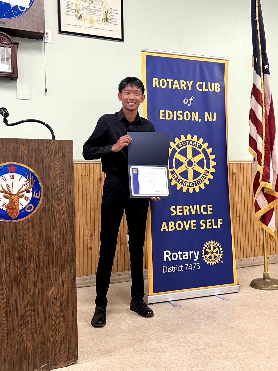 Ryan Lin ’25 smiles with his certificate as October's Rotary Senior of the Month.