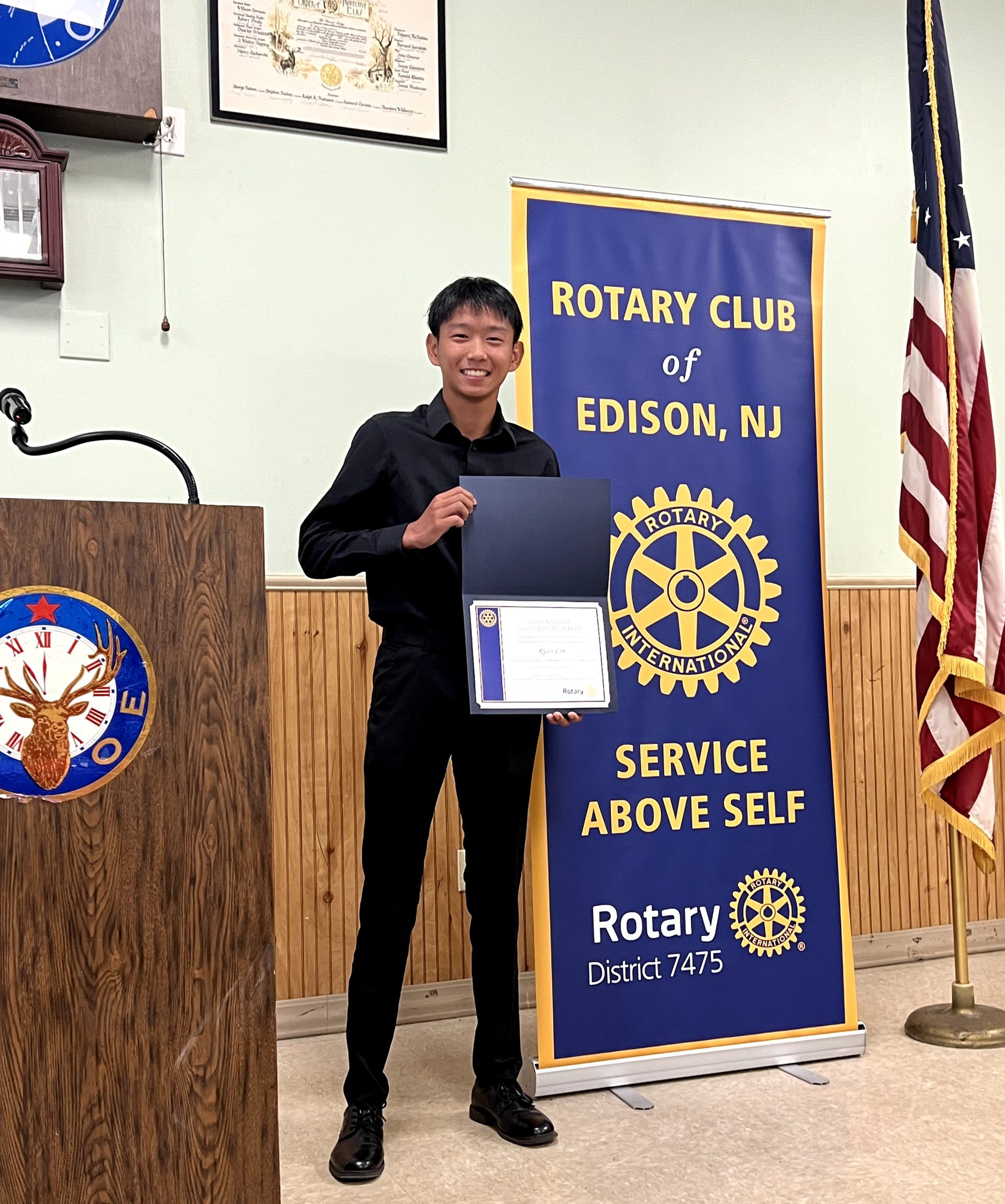 Ryan Lin ’25 smiles with his certificate as October's Rotary Senior of the Month.