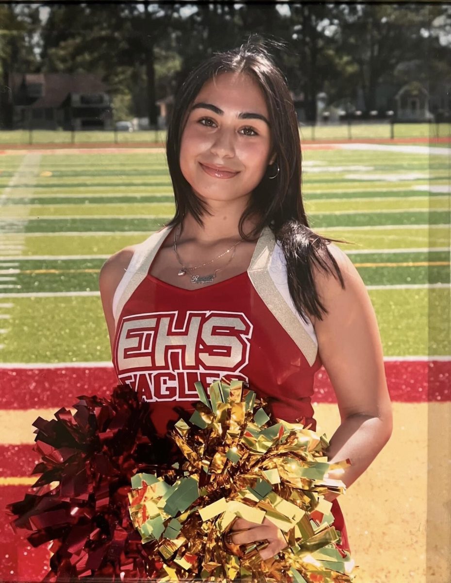 April Godoy '25, the October Rotary Senior of the Month, smiles as she poses for her portrait of herself as a senior varsity cheerleader.