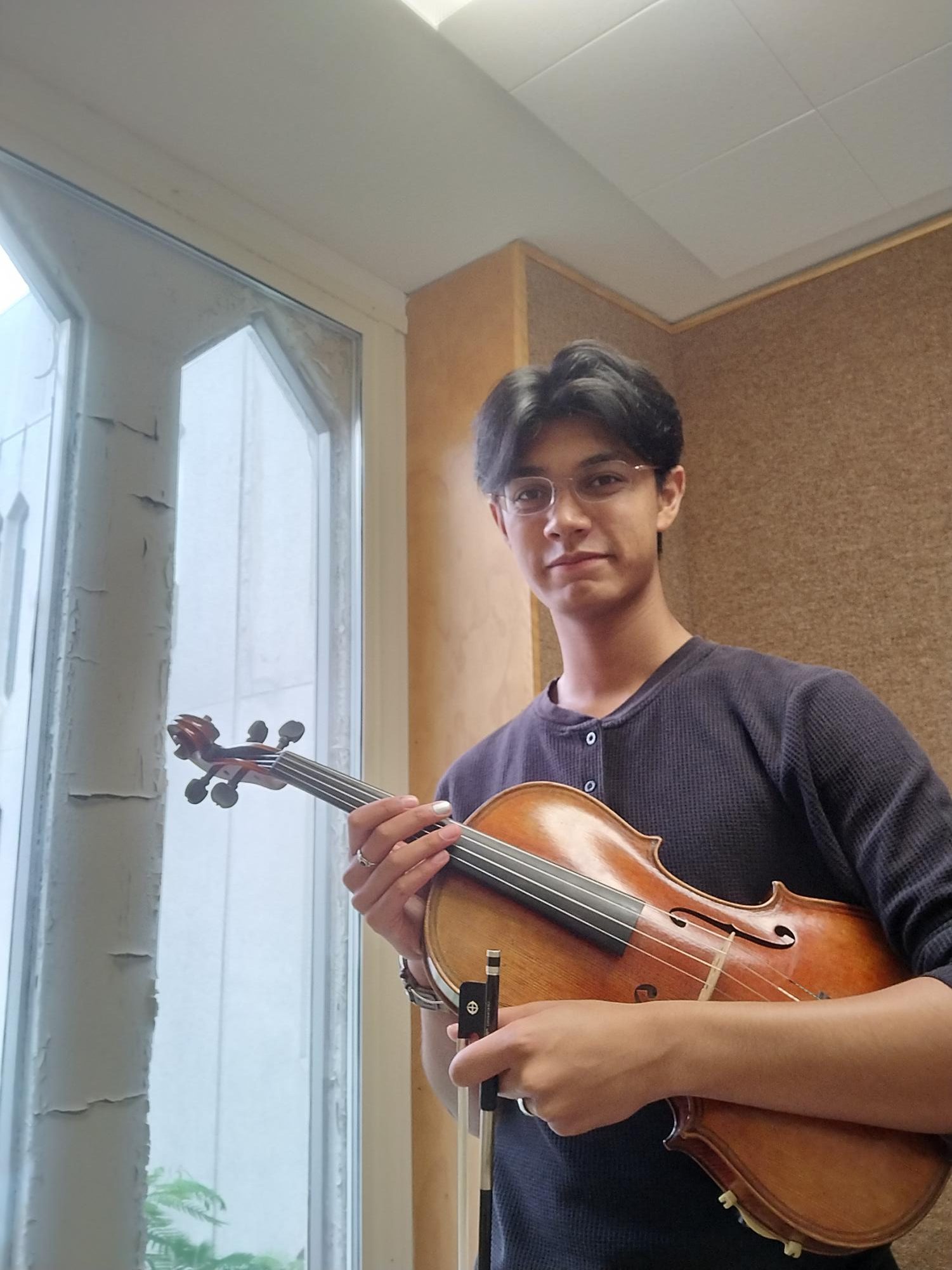 Arman Chotani '25, EHS orchestra member and Rotary's November Senior of the Month, poses with his viola.