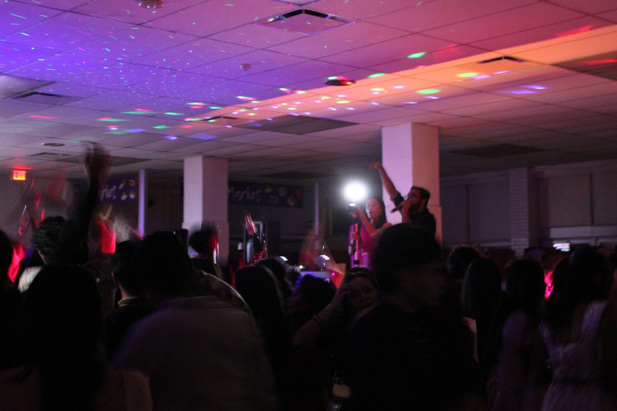 Students surround the DJ as he hypes up the crowd with a remix of South Asian songs.