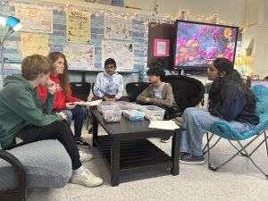 Ms. Guas, an English teacher at EHS, discusses a FOIL assignment with her period 9-10 students in her comfortable seating corner. 