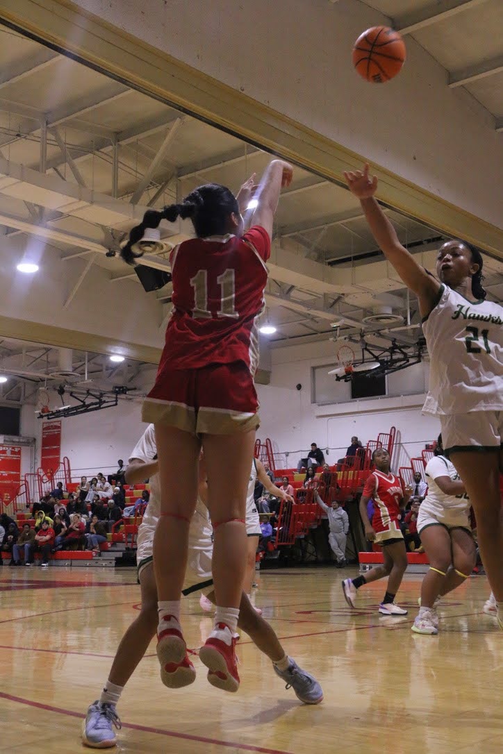 Carmela Arana ‘28 shoots from the three-point line as the defense closes in.