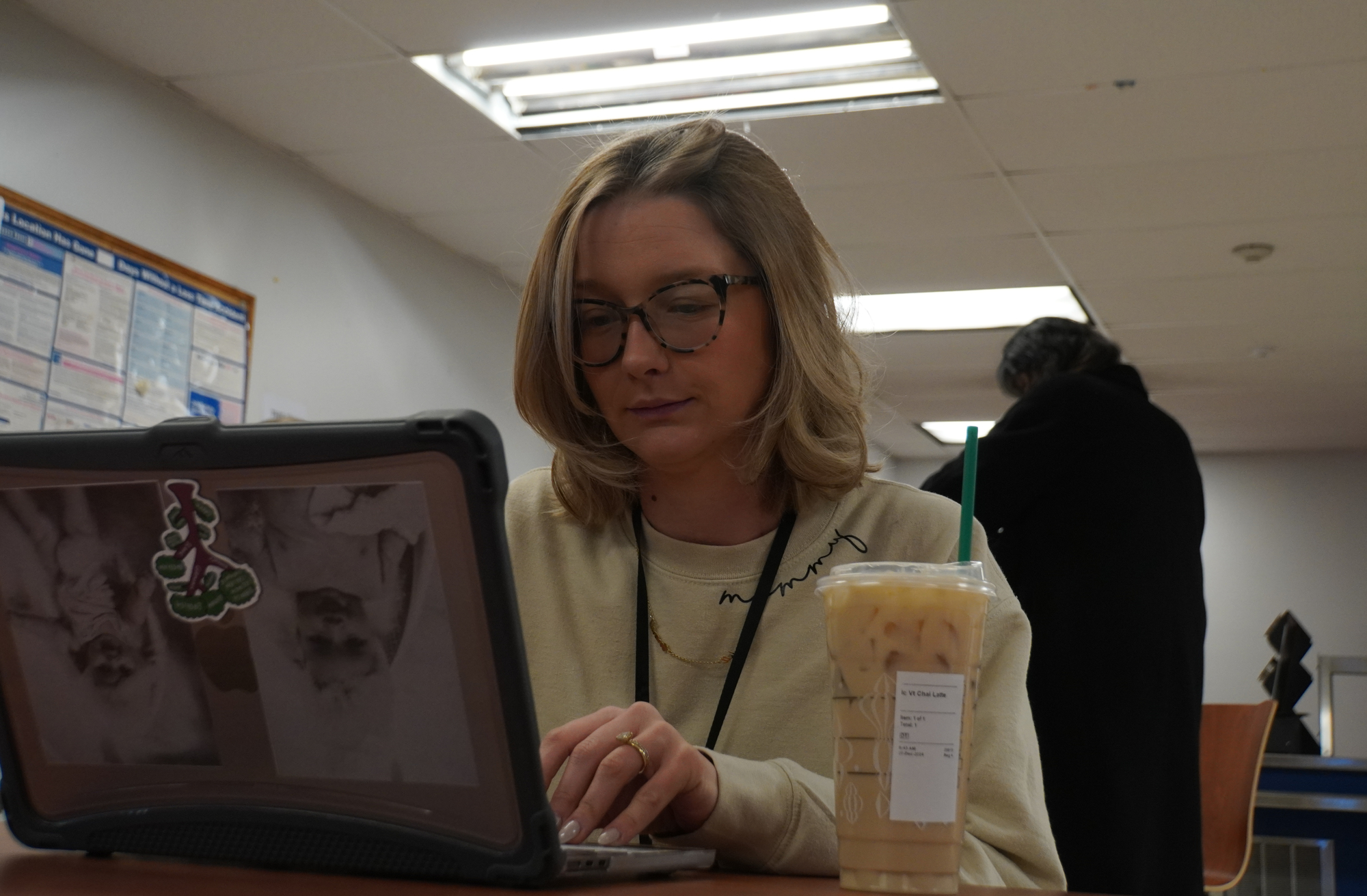 A worldwide educator, Ms. Emila Ascolese finishes up work on her computer in the Faculty Room next to her Starbucks latte.