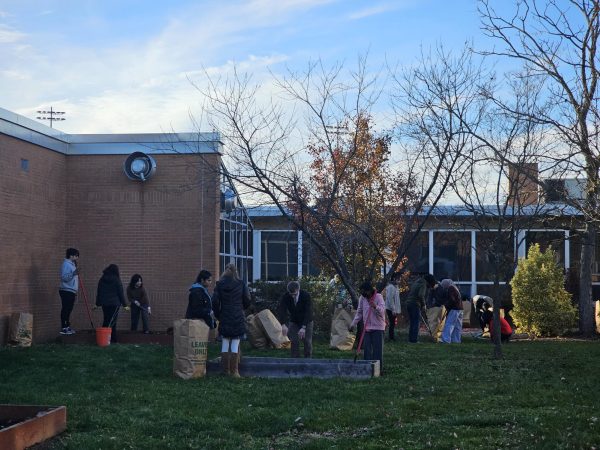 Club advisor Dr. Jonathan Clark and the members of the Latin Club fill the flower beds with soil to begin the garden for the spring. The club maintains parts of the school's inner courtyard.