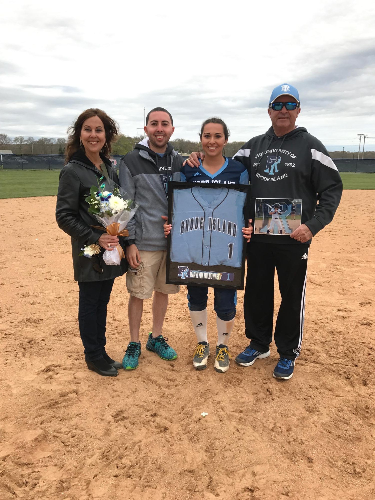 Decked out in University of Rhode Island merchandise, the Muldowney family supports Ms. Marylynn Muldowney and her softball career.
“We spent countless hours traveling to watch our children — Joseph, Vincent, Anthony, and Marylynn — play, always supporting their dreams. As they grew older, he remained deeply involved and present in their lives. He believed that a loving family is the foundation for a child’s future, and he lived that belief every day.” — Ms. Ann Muldowney, wife of Muldowney.