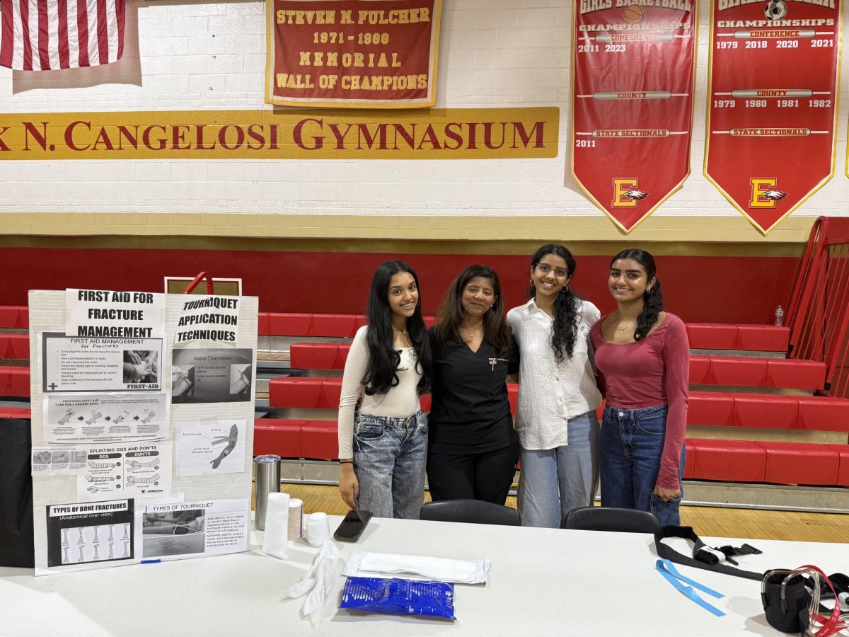 (from left to right) Aashi Tamboli '26, physician assistant Shruti Jhaveri, Pragya Bhatia '26, and Keya Patel '26 engage at the fracture management and tourniquet application stand.