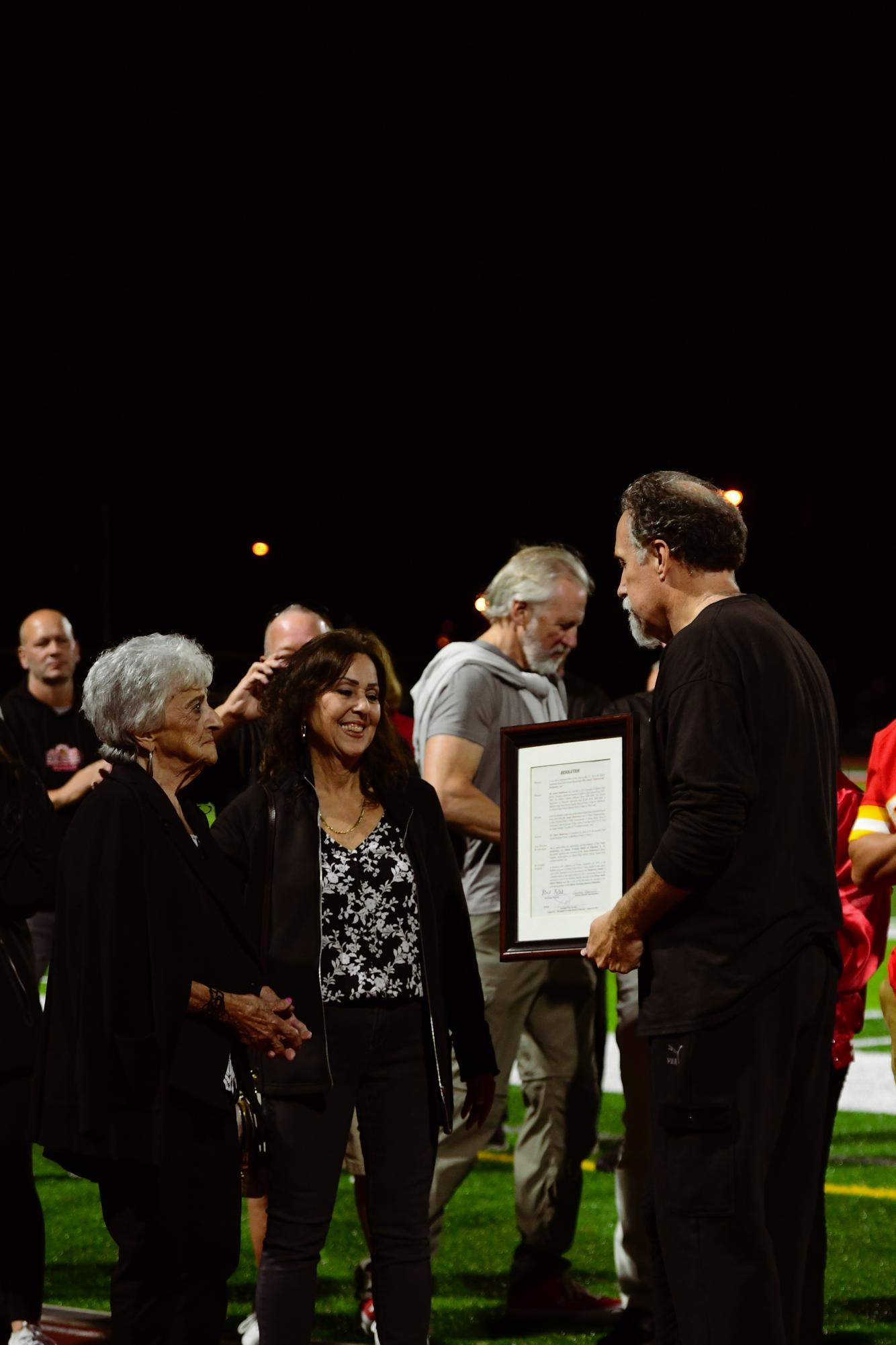 Edison High School principal Mr. Charles Ross awards Mr. James Muldowney's family with a School Board resolution officially retiring Muldowney's number across all EHS sports.