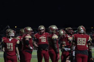 Edison football players huddle together, regrouping before the next play.