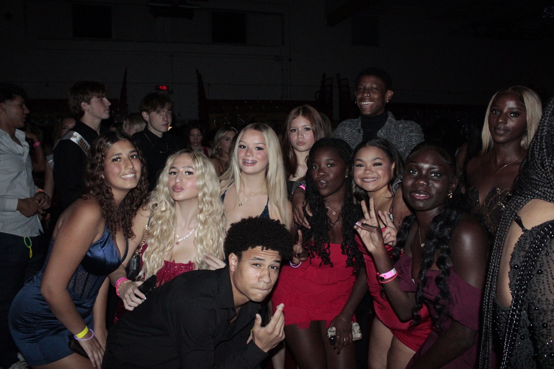 Students huddle for a photo amidst energetic music and a charged atmosphere during the NYC-themed Homecoming.