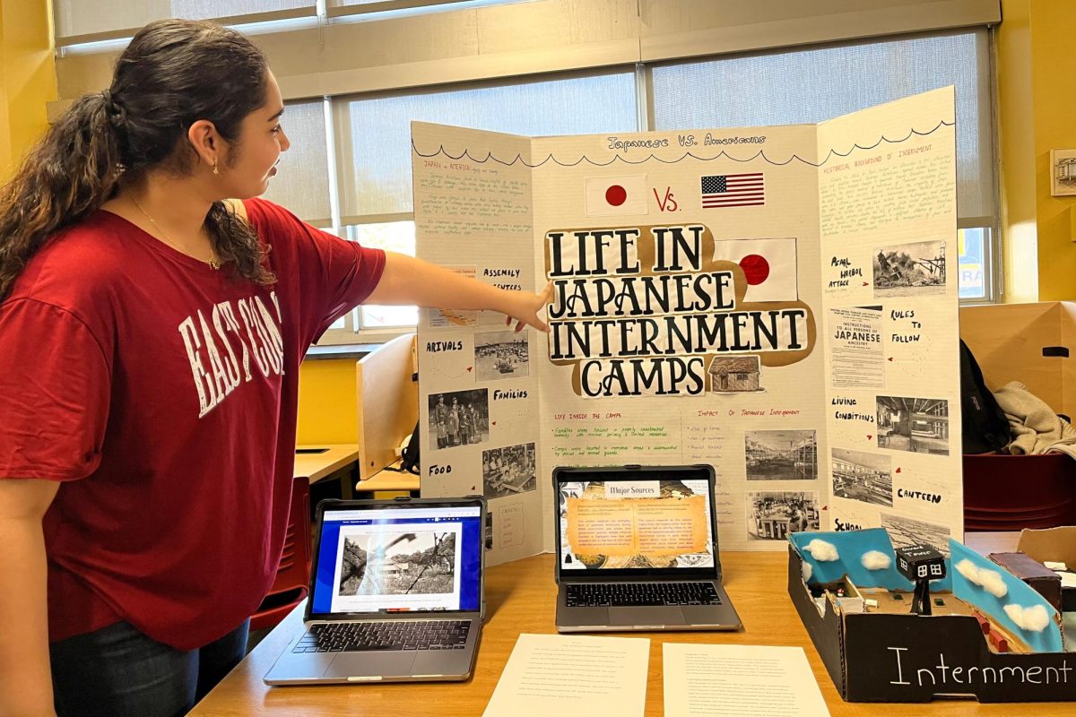 Saraghavi Gollamudi '28 explains her group's project to visitors and classmates taking part in the gallery walk, highlighting the history of the treatment of Japanese Americans by the US government during World War II.