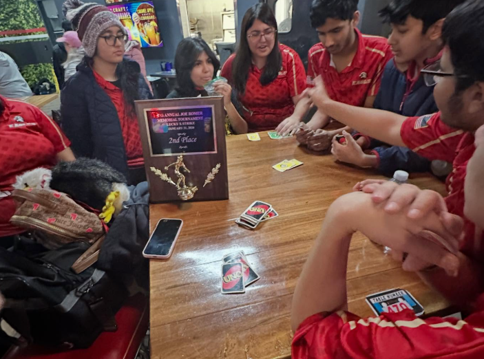 EHS' boys and girls bowling team play Uno post-game, celebrating their match's outcome. The team's high third-round margin secured their victory over JP Stevens on January 14th.