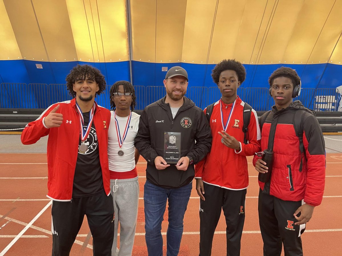 Mr. John Krajunus stands with members of the Edison High School track team at the 2025 Demarest Invitational. Since 2017, Krajunus has emphasized a positive, high-achieving atmosphere.