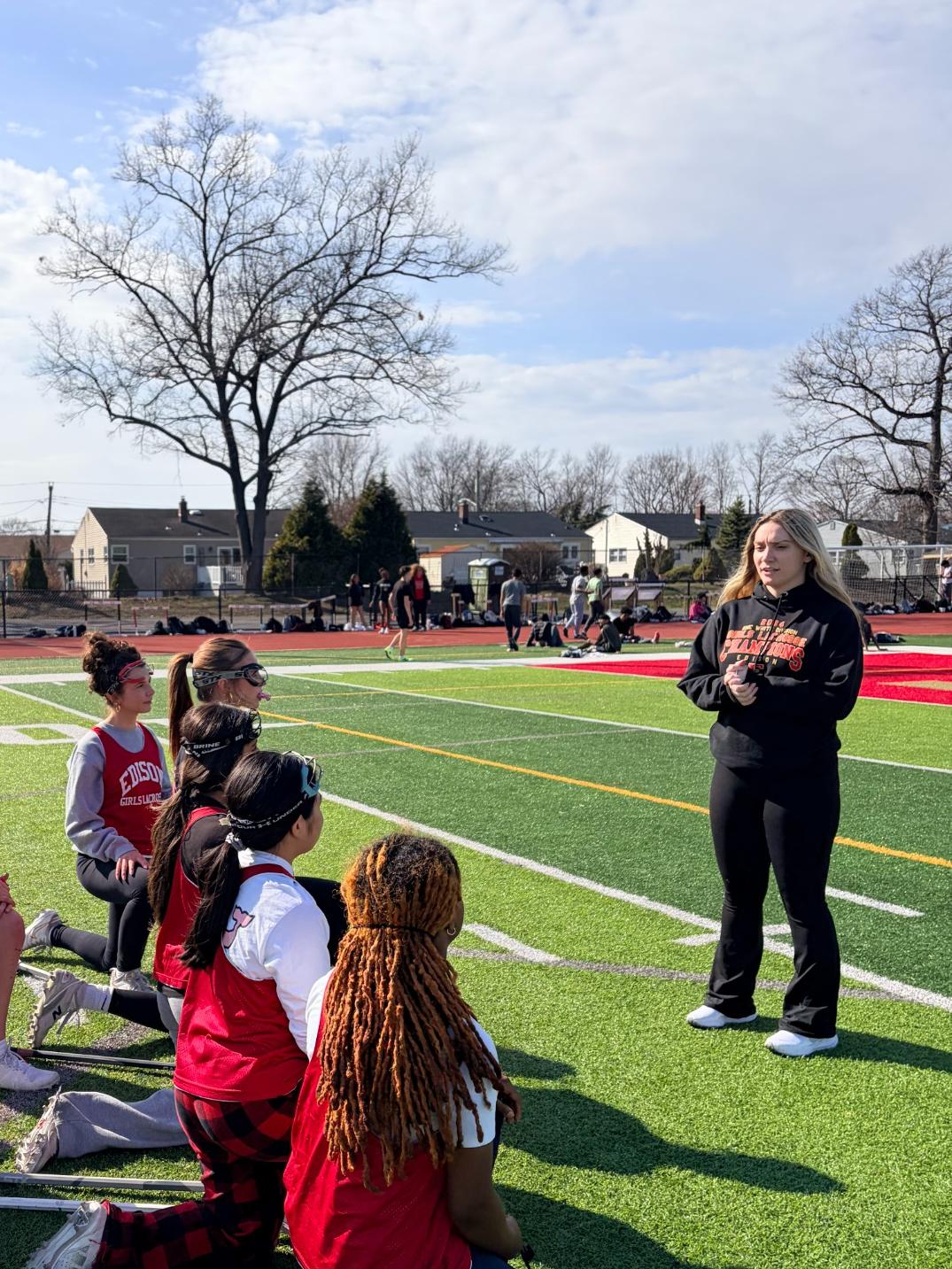 Coach Sara Yocum addresses her team during a mid-practice huddle, reinforcing her core values of perseverance, development, and accountability as the foundation of Edison High’s girls lacrosse team.