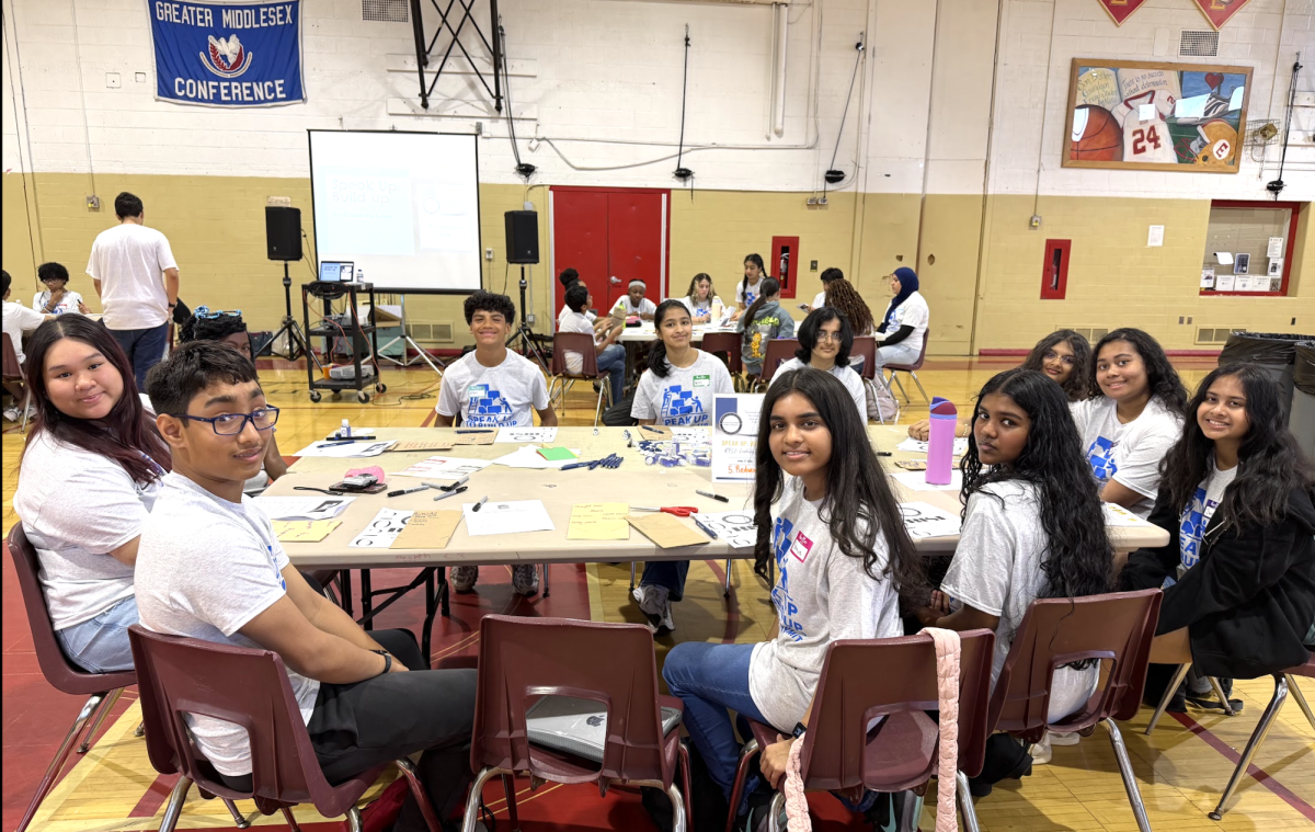 Student leaders gather around a workshop table during a collaborative group activity at the RISE Student Leadership Conference.